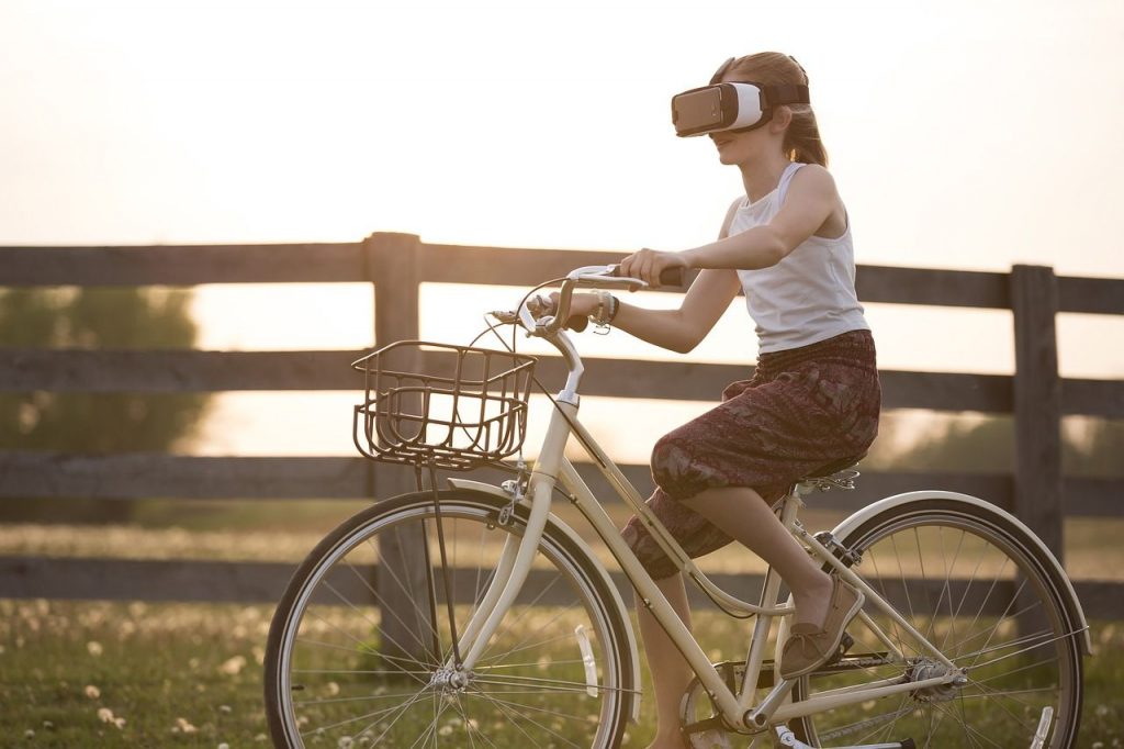 Girl riding a bike wearing a Virtual Reality headset