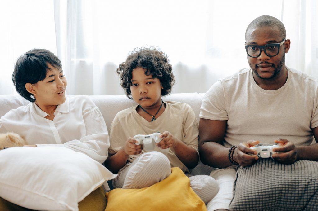 School Child playing games with Family on the couch