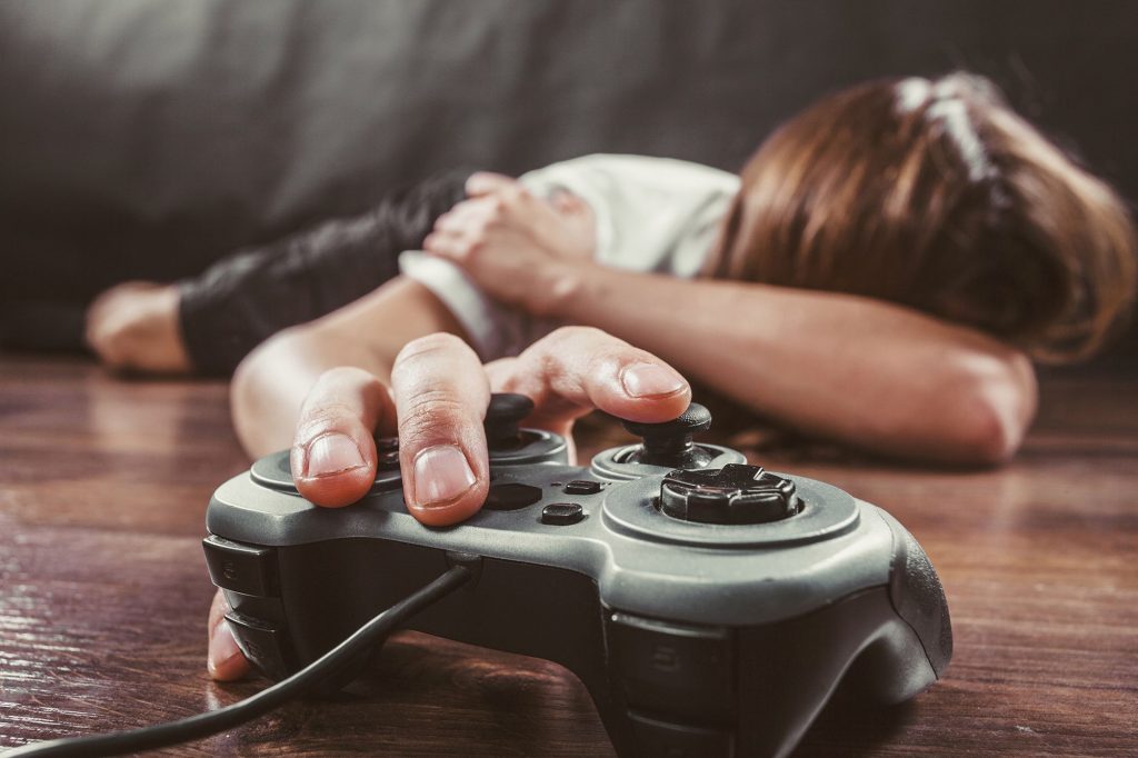 Person lying on the floor suffering from Video Game Addiction