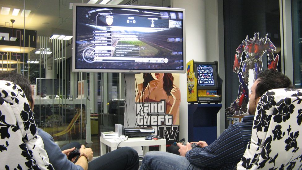 Two men playing FIFA in an office