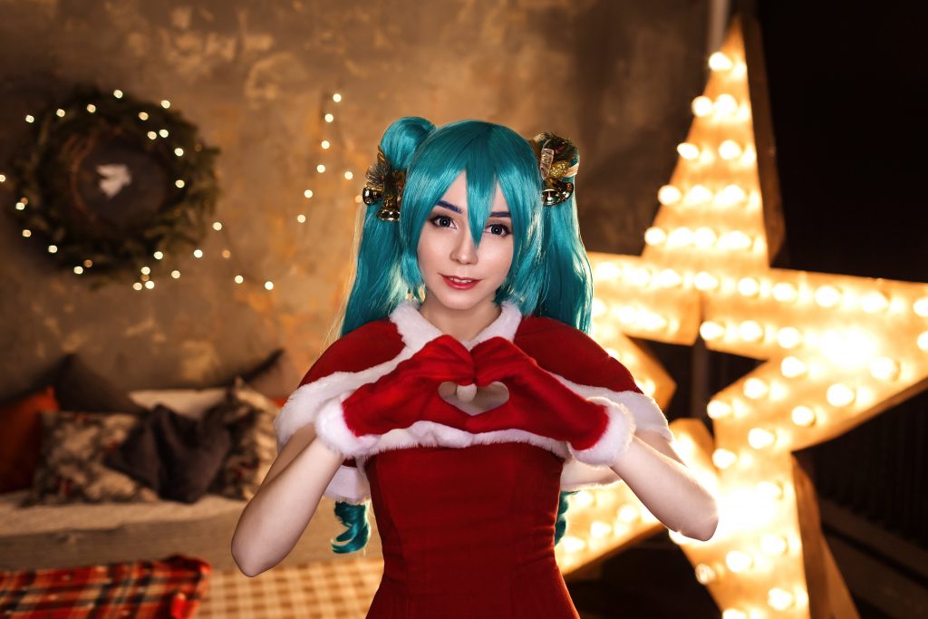 Cute cosplayer girl cosplaying Christmas Miku Santa dress around