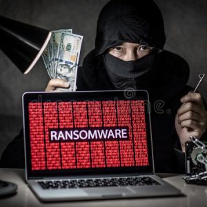 Ransomware on a laptop with hacker standing behind it