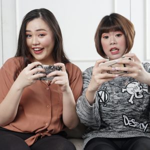 Two Asian Female Gamers Playing on their phones