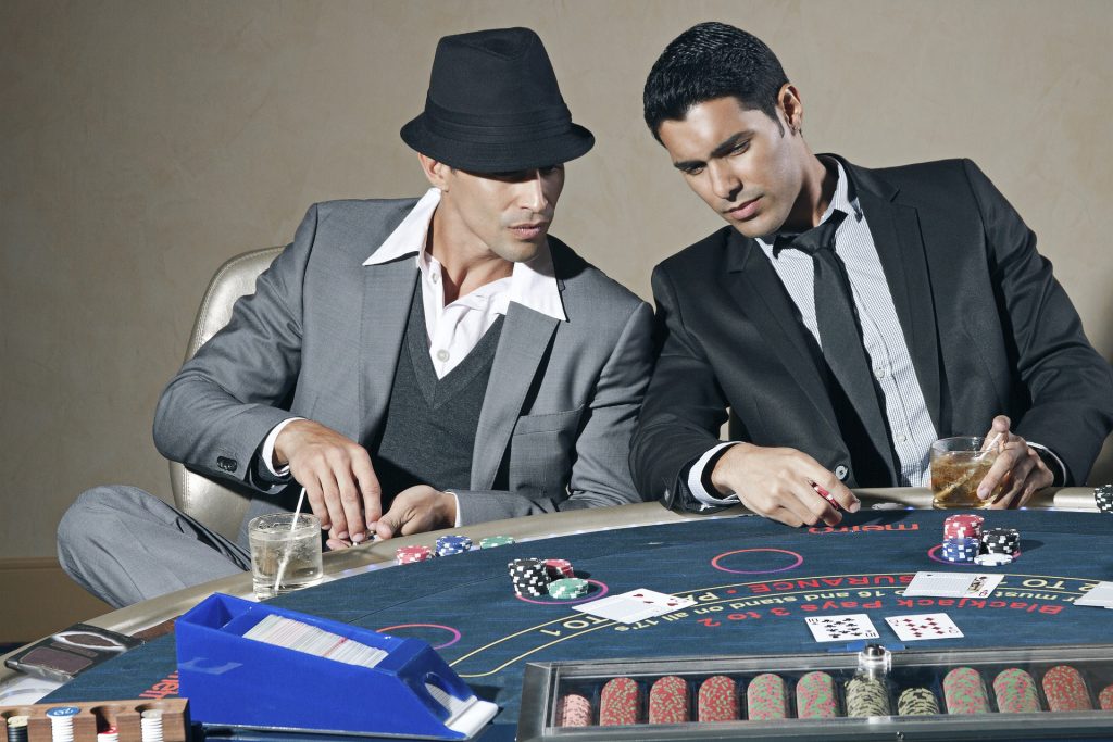 Two players playing cards at a casino table