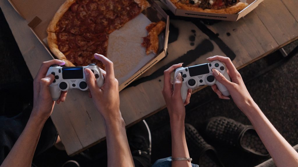 In between games, it's important to have food. Like in this image which shows two players with a pizza on the table infront of them.