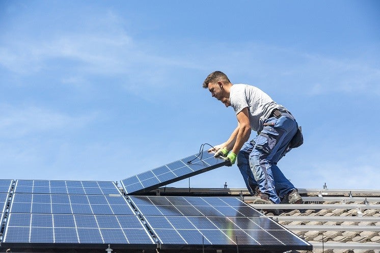 Man Installing solar panels on a roof