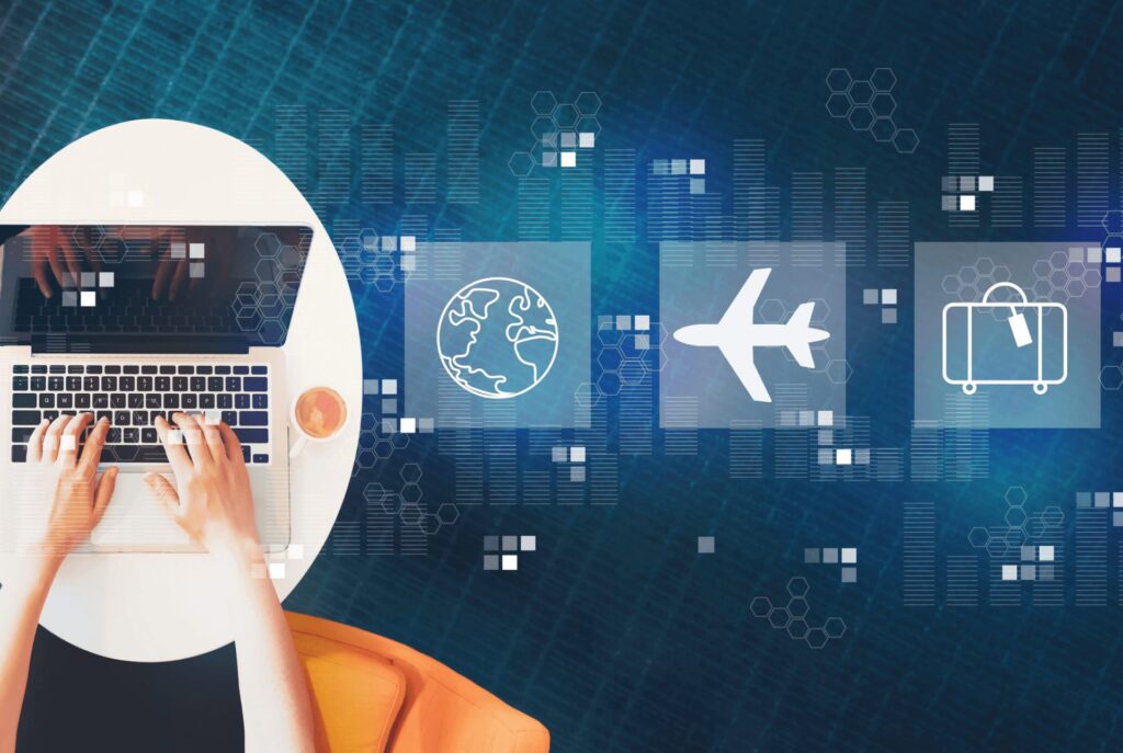A laptop next to travel icons showing the relationship between the travel industry and technology