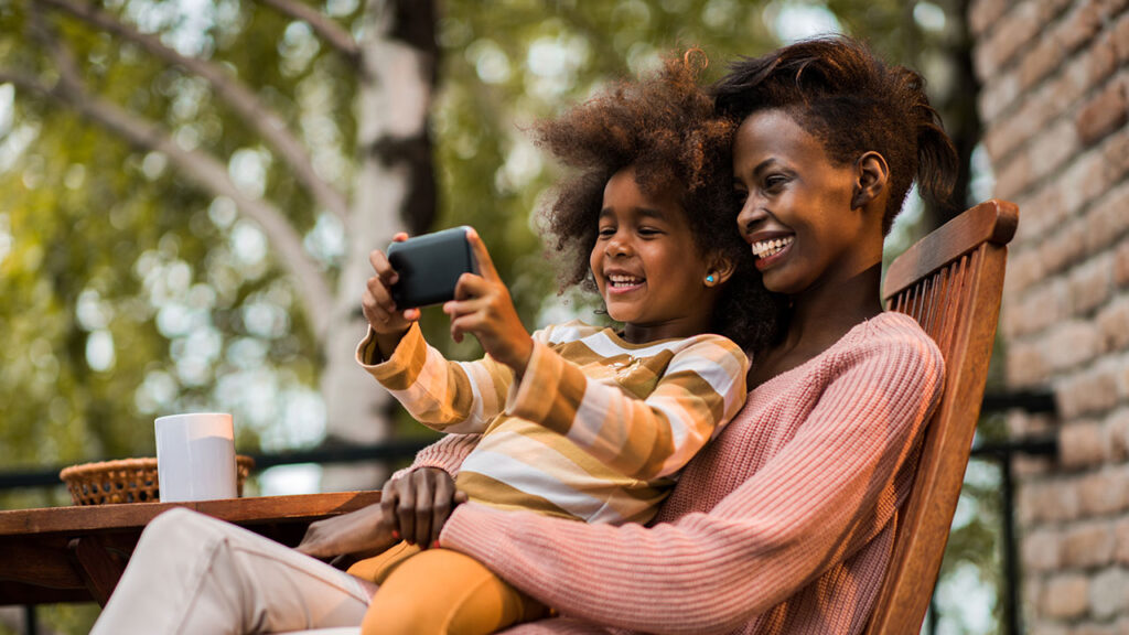 Parent watching a video on their phone with child