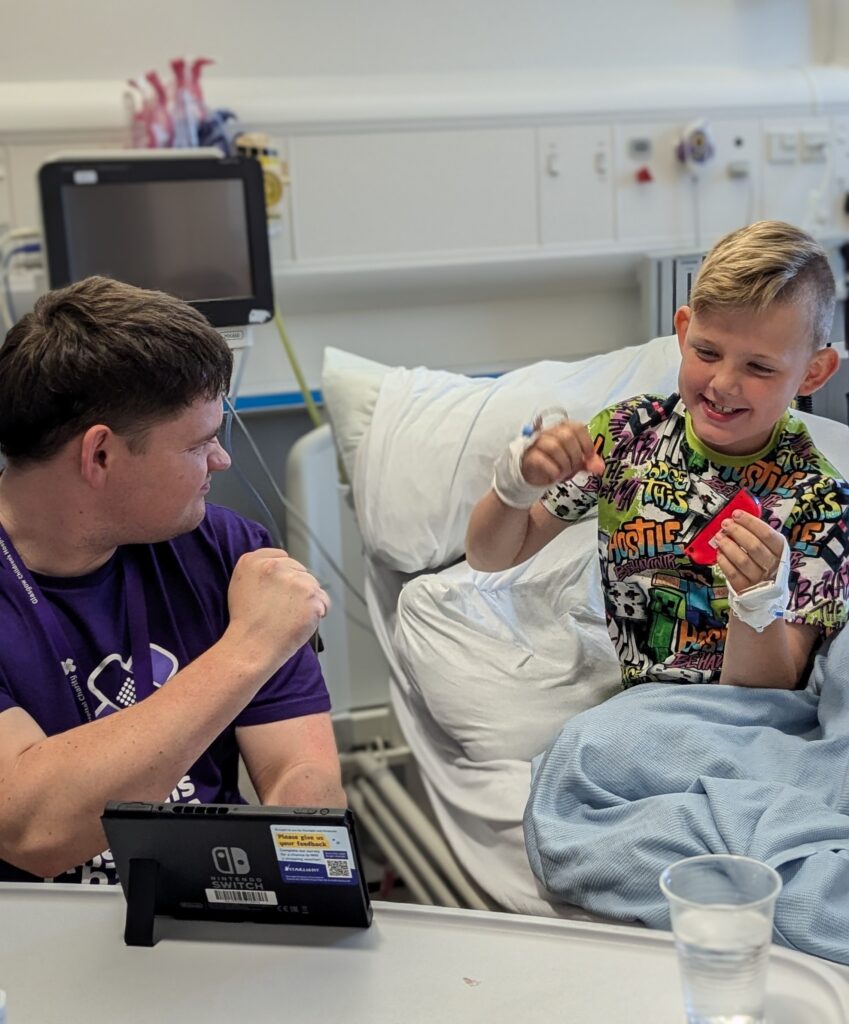 Gamer-in-Residence, Steven Mair (26) plays with eight-year-old patient Martin at the Royal Hospital for Children in Glasgow, Scotland.