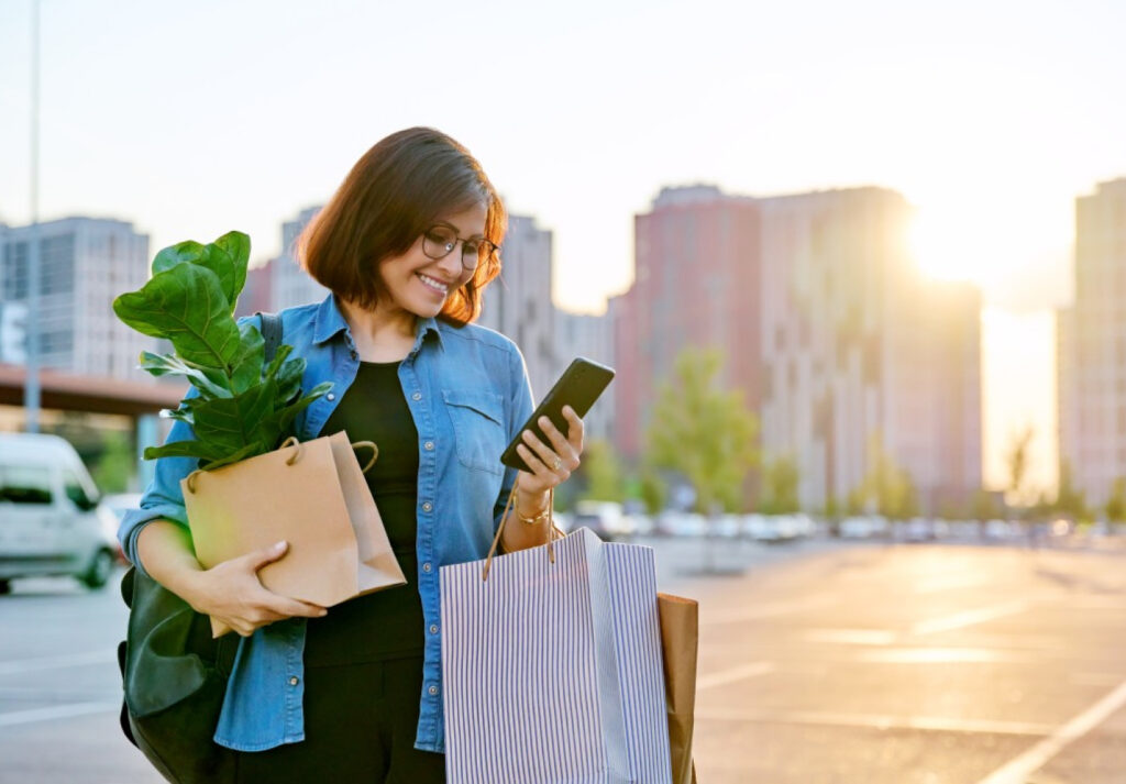 The rise of micro-moments: How we’re filling the gaps in our day 3 Women on her phone whilst carrying shopping having a micro-moment